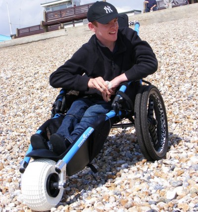 Sitting in a Hippocampe Beach Wheelchair on a pebbly beach